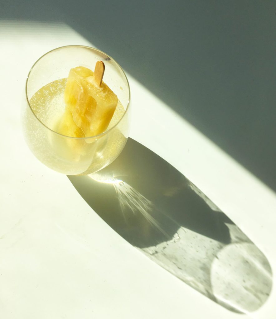 Adding a popsicle to fizzy water for a delicious way to sweeten and flavor it.
