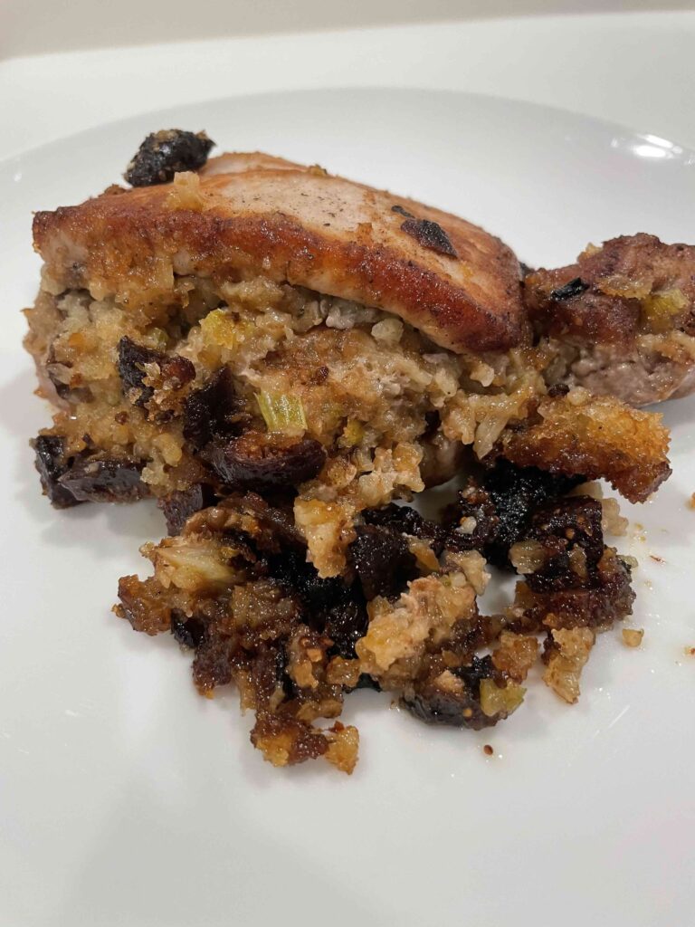 Fig stuffed pork chops on a white plate