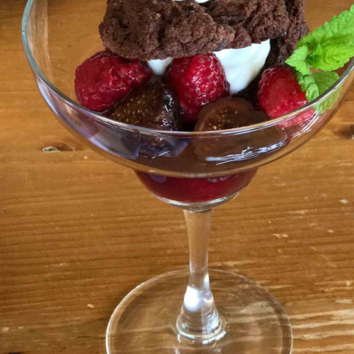 A pretty glass filled with chocolate shortcake with raspberries and figs. Learn how to make the fig compote recipe too.