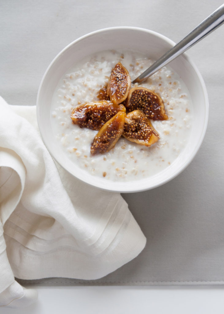 A napkin tucked in beside a bowl of perfect oatmeal with honey fig topping
