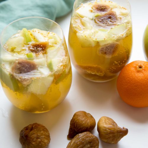 Fig sangria full of oozy fruit topped with ginger ale in cups and ready to sip