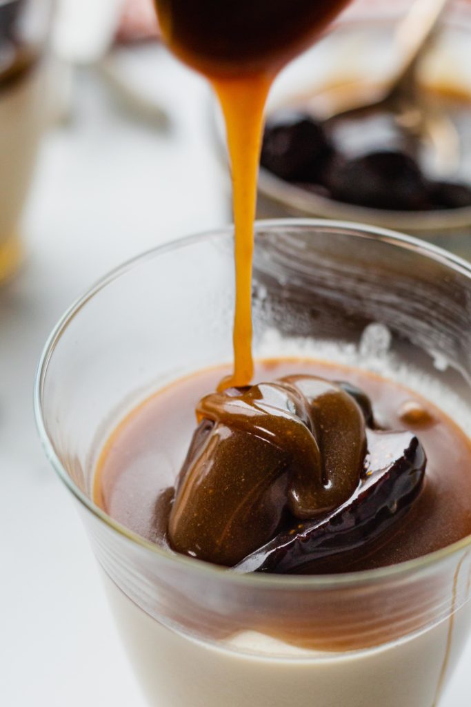 Caramel sauce drips onto a sweet cream panna cotta with figs.