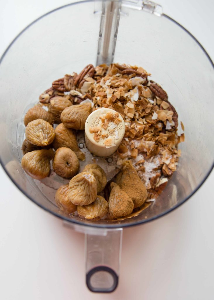 Golden figs with pecans and coconuts with spices ready to pulvierize in a food processor.