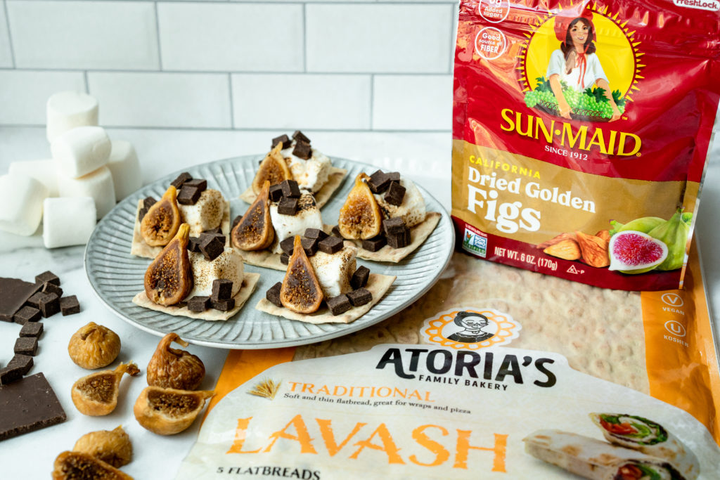 Plate of fig smores on crispy lavash with a bag of Sun-Maid California Dried Golden Figs and Atoria's Family Bakery Lavash.
