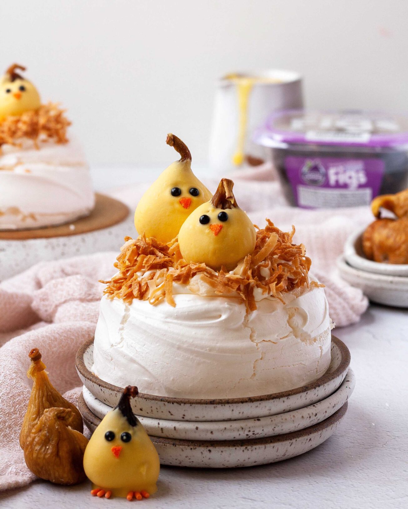 Valley Fig Chicks perched inside a pavlova nest with toasted coconut—light Easter desserts for your festive table.