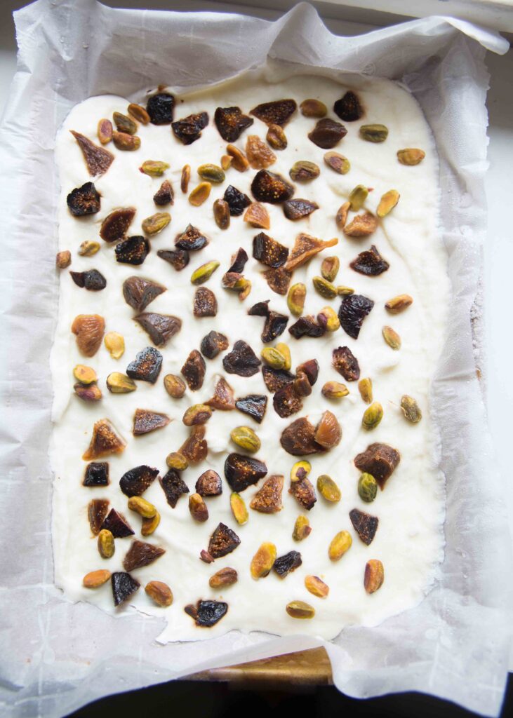 Pan of yogurt bark topped with figs and pistachios, straight from the freezer