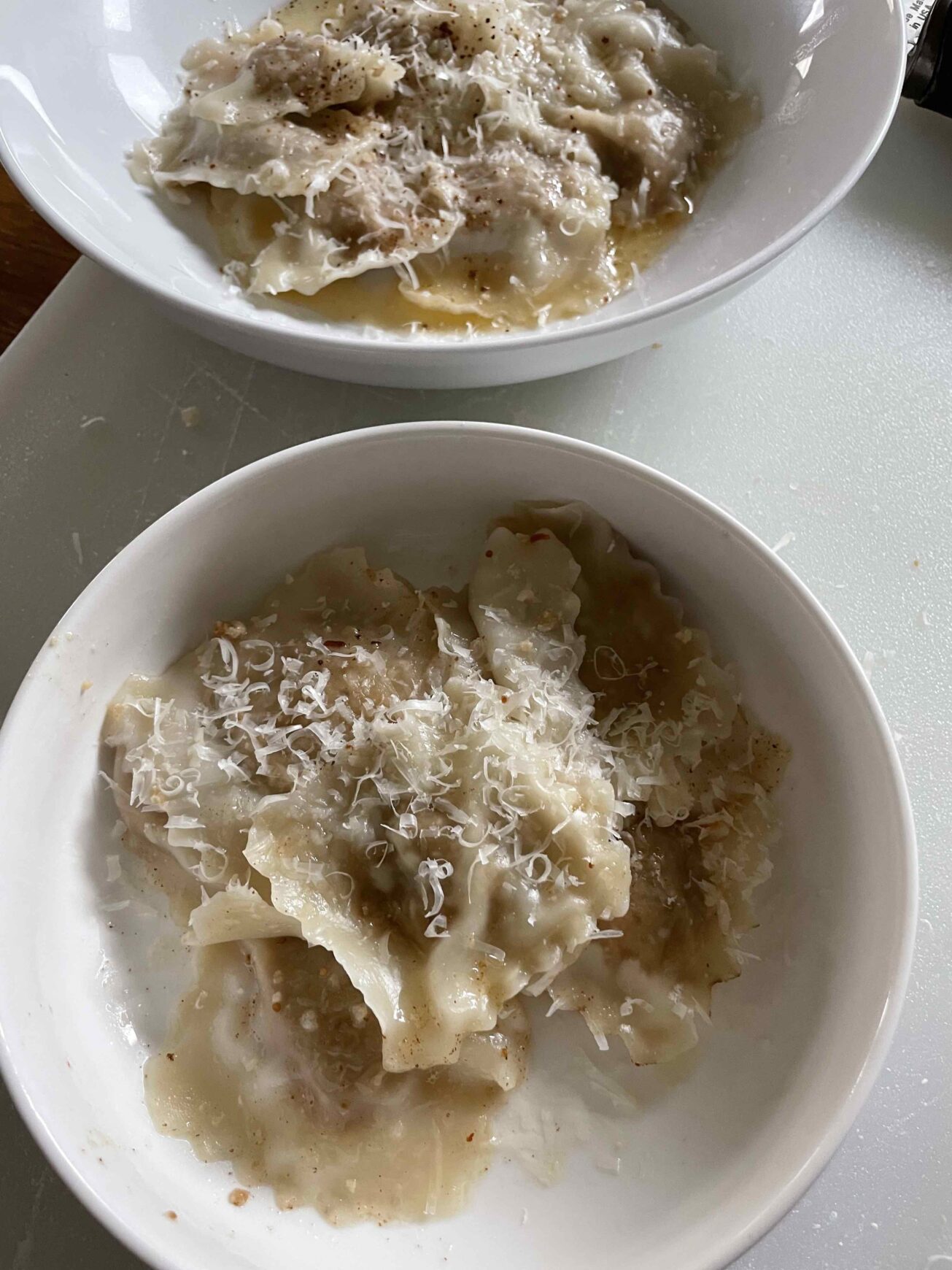 A bowl of ravioli with fig and goat cheese filling inside