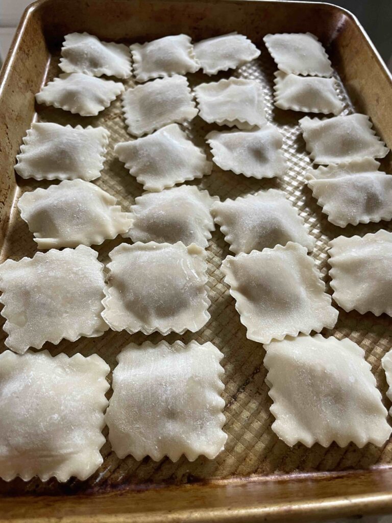 Prepping the uncooked ravioli to be frozen
