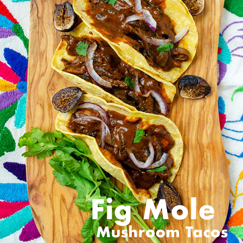 Tacos filled with fig mole mushrooms on a wooden board
