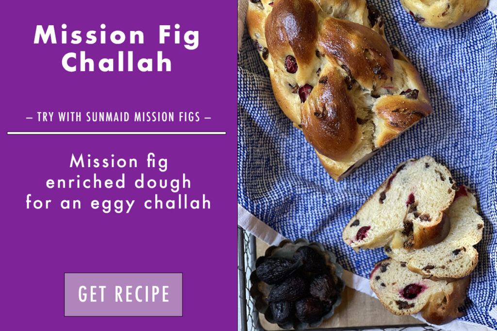 challah loaf on blue towel with figs and slices of challah